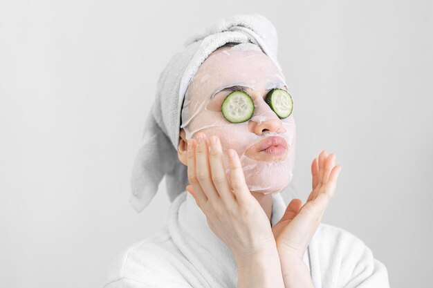 Giovane donna con maschera in tessuto sul viso procedura spa