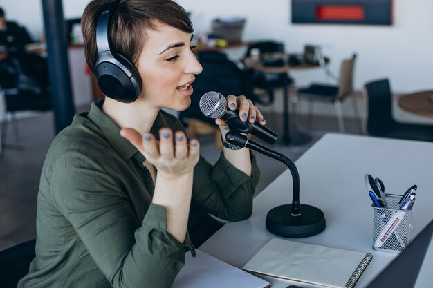 Giovane donna con microfono registrazione recitazione vocale