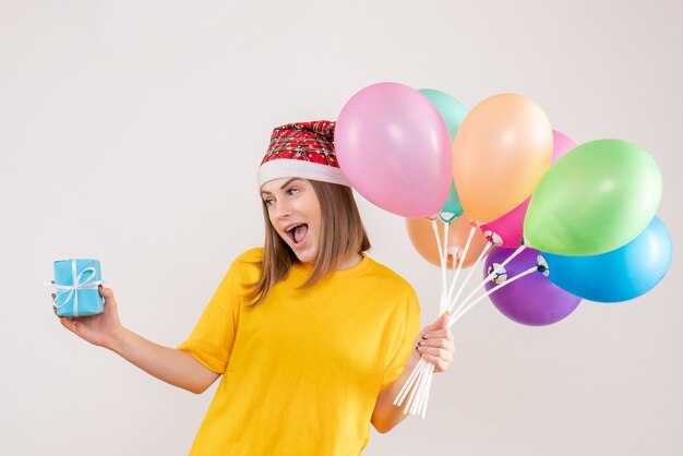 giovane donna con poco presente e palloncini colorati su bianco