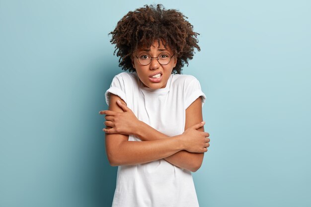 Giovane donna con taglio di capelli afro che indossa la maglietta bianca