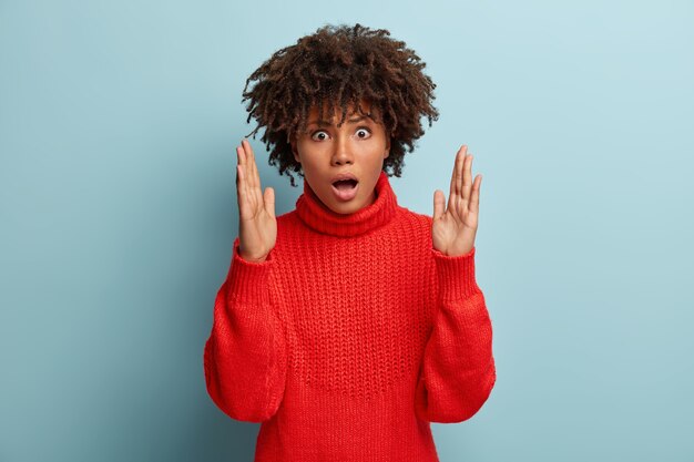 Giovane donna con taglio di capelli afro che indossa un maglione rosso