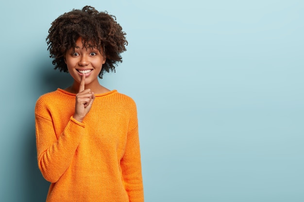 Giovane donna con taglio di capelli afro che indossa un maglione