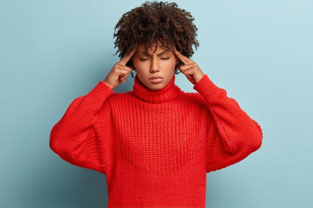 Giovane donna con taglio di capelli afro che indossa un maglione