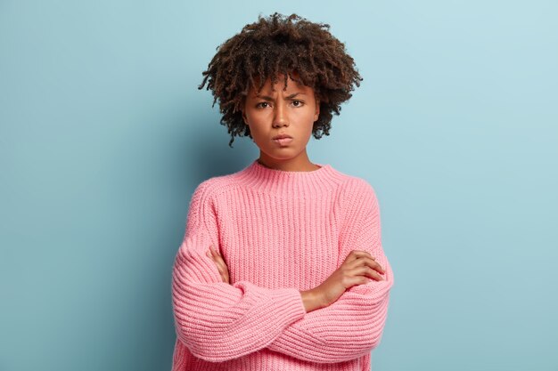 Giovane donna con taglio di capelli afro che indossa un maglione