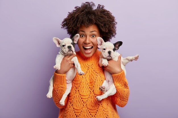 Giovane donna con taglio di capelli afro che tiene i cuccioli