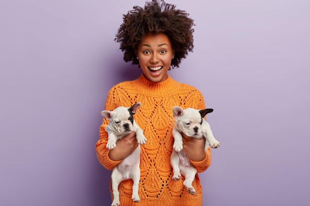 Giovane donna con taglio di capelli afro che tiene i cuccioli