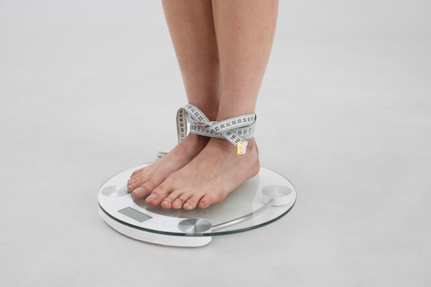 Giovane donna con un disturbo alimentare che utilizza un metro a nastro