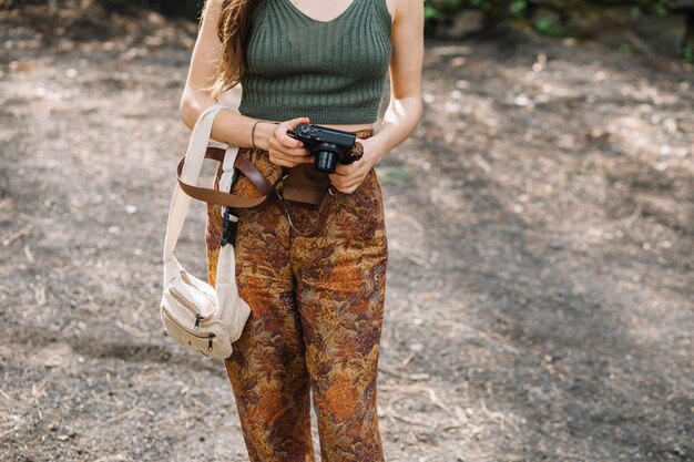 Giovane donna con una macchina fotografica in natura