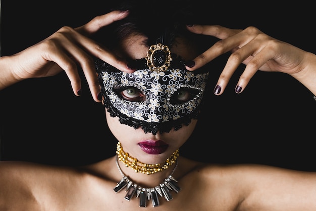 Giovane donna con una maschera veneziana grigio