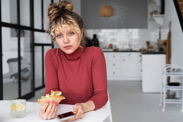 Giovane donna con uno stile di capelli panino disordinato