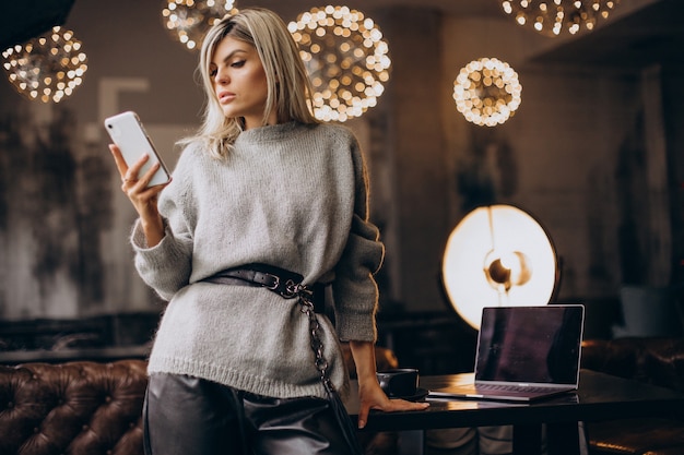 Giovane donna d'affari che parla al telefono in un caffè