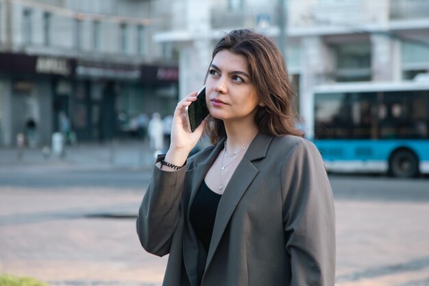 Giovane donna d'affari con uno smartphone su uno sfondo sfocato della città