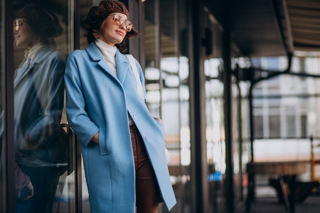 Giovane donna d'affari in cappotto blu dal caffè