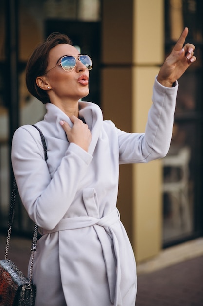 Giovane donna d&#39;affari in cappotto fuori strada