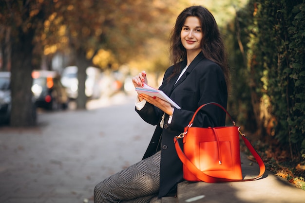 Giovane donna d'affari lettura nel parco