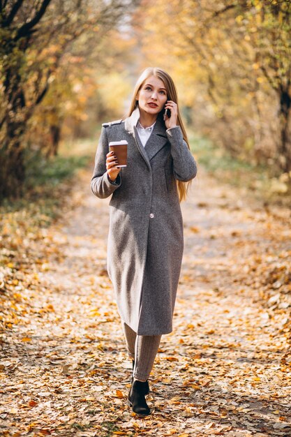 Giovane donna d&#39;affari parlando al telefono e bere caffè