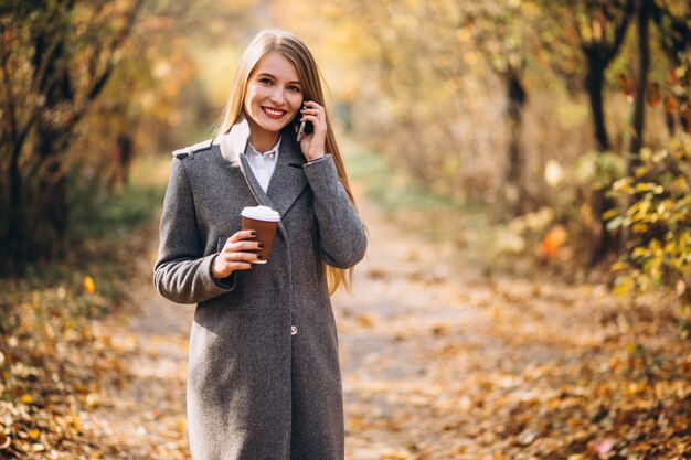 Giovane donna d&#39;affari parlando al telefono e bere caffè