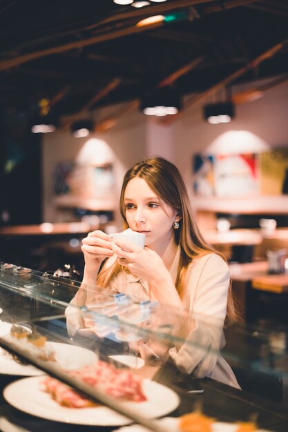 Giovane donna degustazione caffè