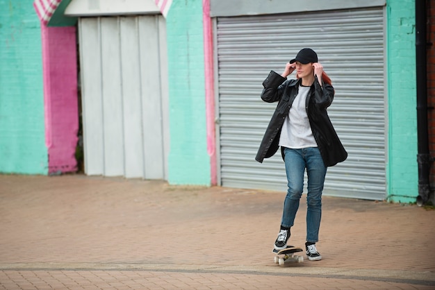 Giovane donna del colpo pieno su skateboard