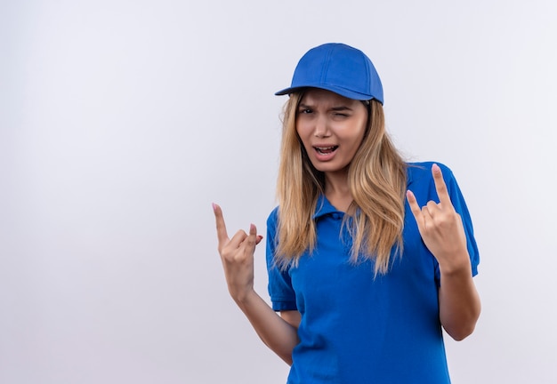 giovane donna delle consegne che indossa l'uniforme blu e cappuccio che mostra il gesto della capra