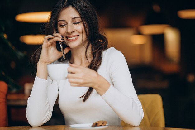 Giovane donna di affari che beve il caffè in un caffè