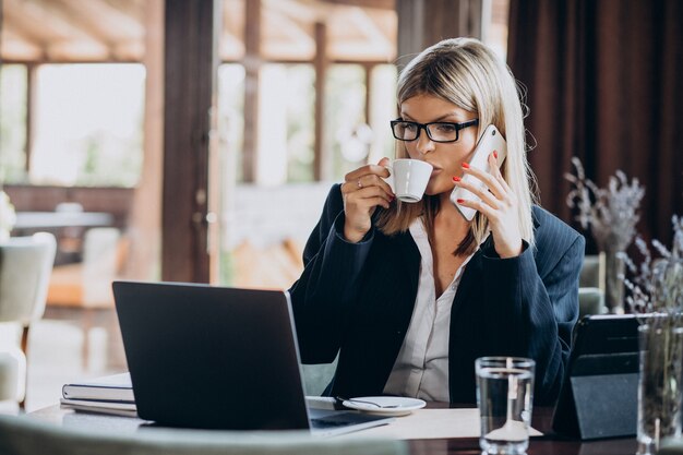 Giovane donna di affari che lavora al computer in un caffè