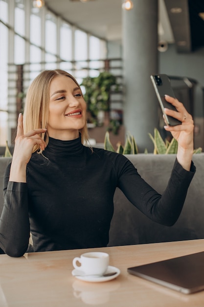 Giovane donna di affari che lavora al computer portatile in un caffè