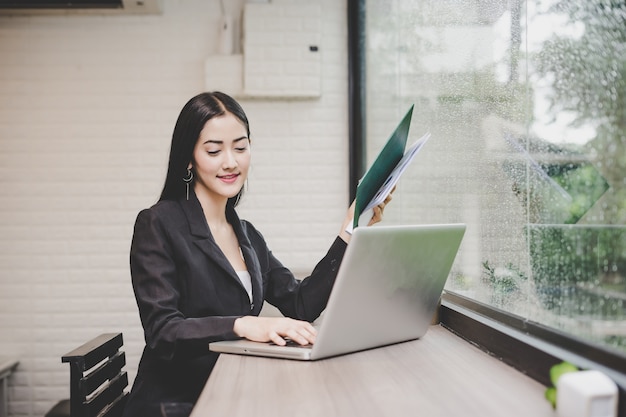 Giovane donna di affari che lavora al computer portatile nell&#39;ufficio