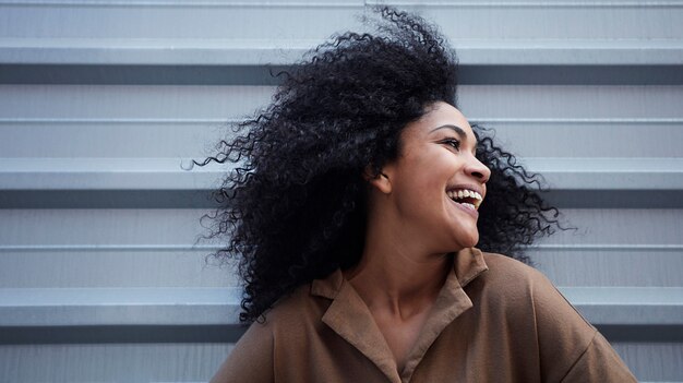 giovane donna di colore con i capelli afro che ride e che gode