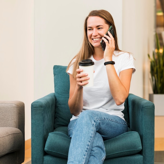 Giovane donna di smiley che parla sul telefono