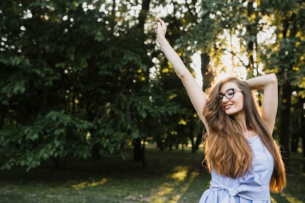 Giovane donna di smiley che sta alla luce del sole