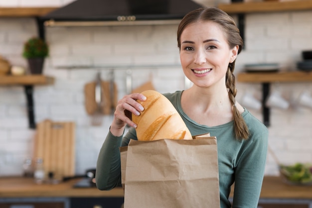 Giovane donna di smiley che tiene pane fresco