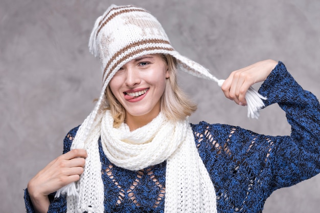 Giovane donna di vista frontale che gioca con il cappello