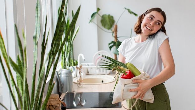 Giovane donna di vista frontale che tiene le verdure bio