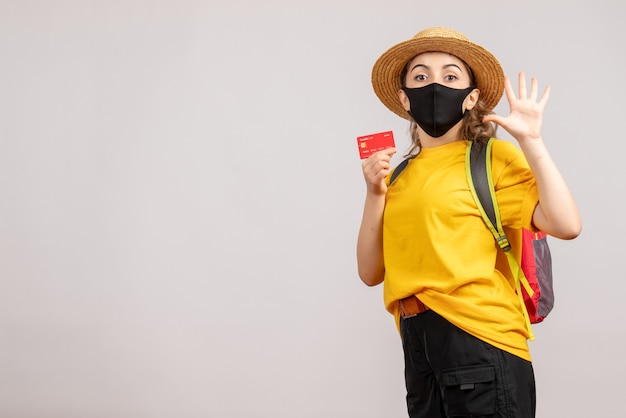 Giovane donna di vista frontale con la carta della tenuta della maschera nera che saluta qualcuno