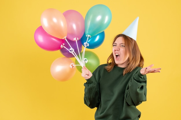 Giovane donna di vista frontale con palloncini colorati