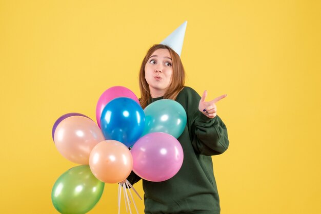 Giovane donna di vista frontale con palloncini colorati