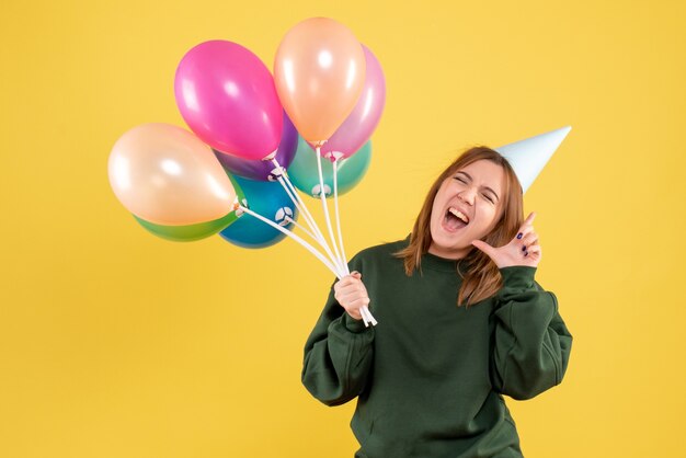 Giovane donna di vista frontale con palloncini colorati