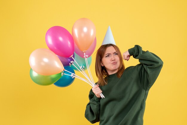 Giovane donna di vista frontale con palloncini colorati