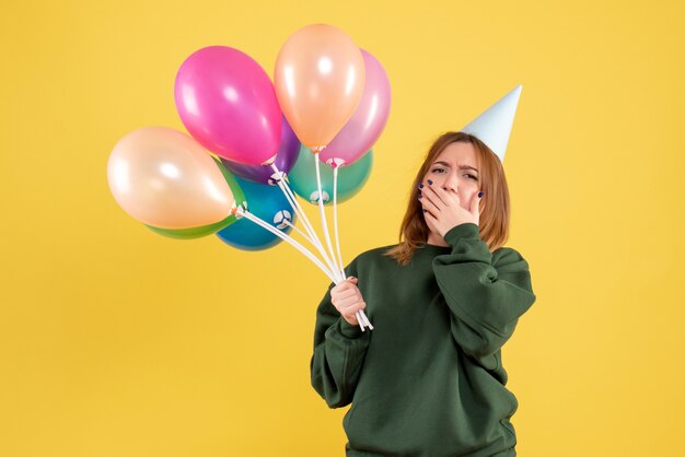 Giovane donna di vista frontale con palloncini colorati