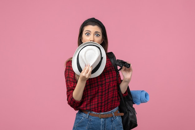 Giovane donna di vista frontale in camicia rossa con il cappello sulla donna di colore umano sfondo rosa