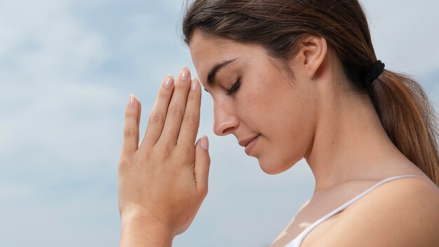 Giovane donna di vista laterale che medita