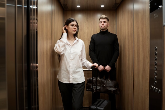 Giovane donna e giovane che prendono l'ascensore in un hotel