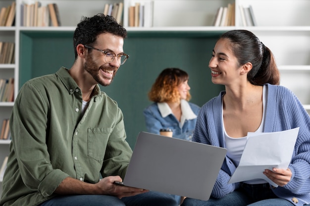 Giovane donna e uomo che leggono dalle note durante la sessione di studio