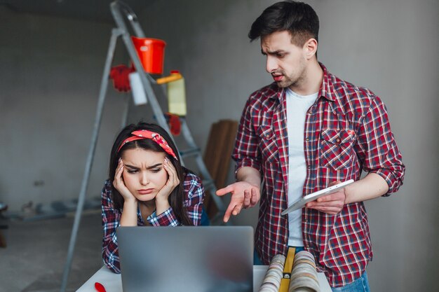 Giovane donna e uomo che litigano durante i lavori di ristrutturazione in appartamento