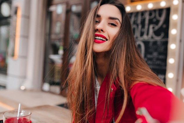 Giovane donna elegante con capelli scuri che gode della passeggiata intorno alla città