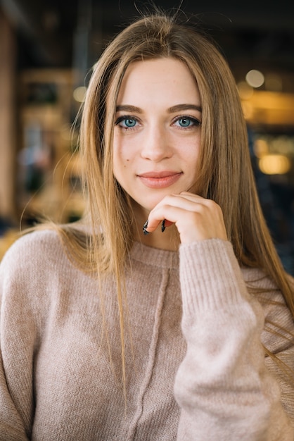 Giovane donna elegante positiva attraente in caffè