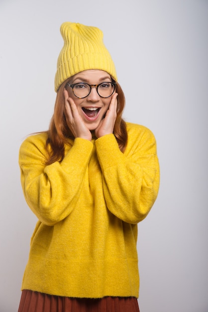 Giovane donna emozionante in cappello lavorato a maglia