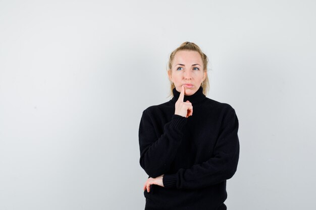 Giovane donna espressiva che posa nello studio