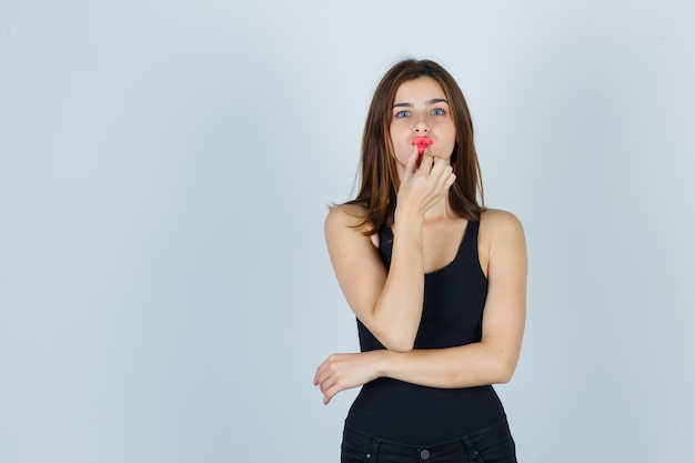 Giovane donna espressiva che posa nello studio